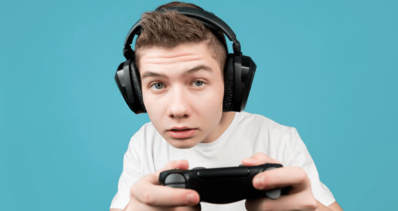 boy wearing headphones with a game console controller in his hands