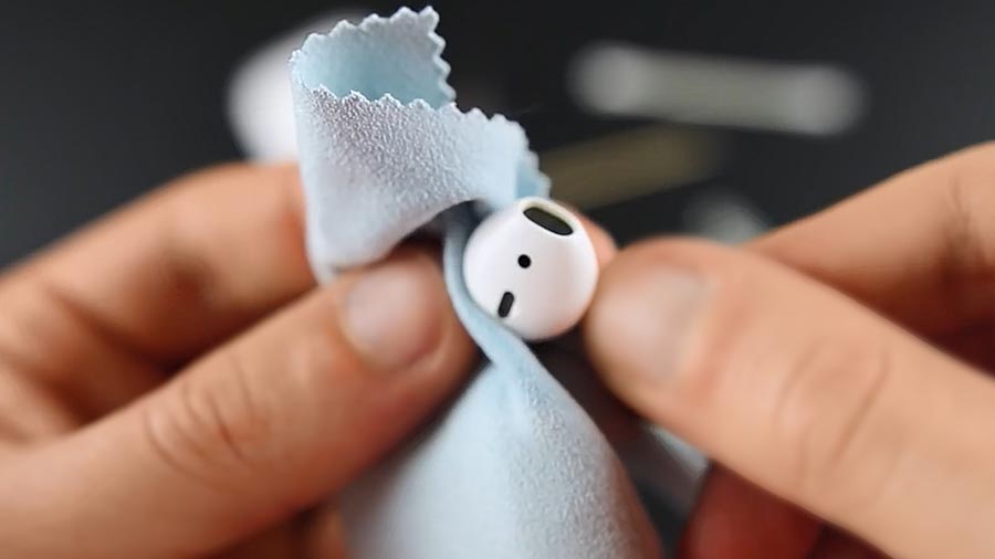 Cleaning AirPods with a microfiber cloth.