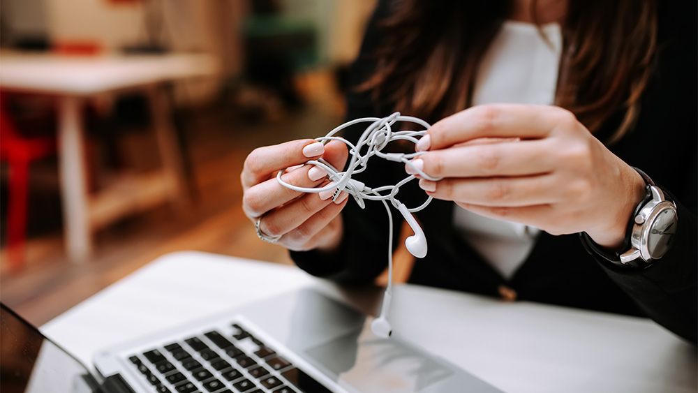 woman holding tangled headphones